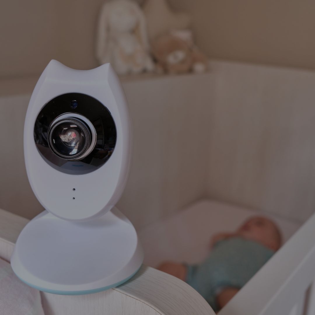 Baby monitor camera watching baby sleeping safely in crib
