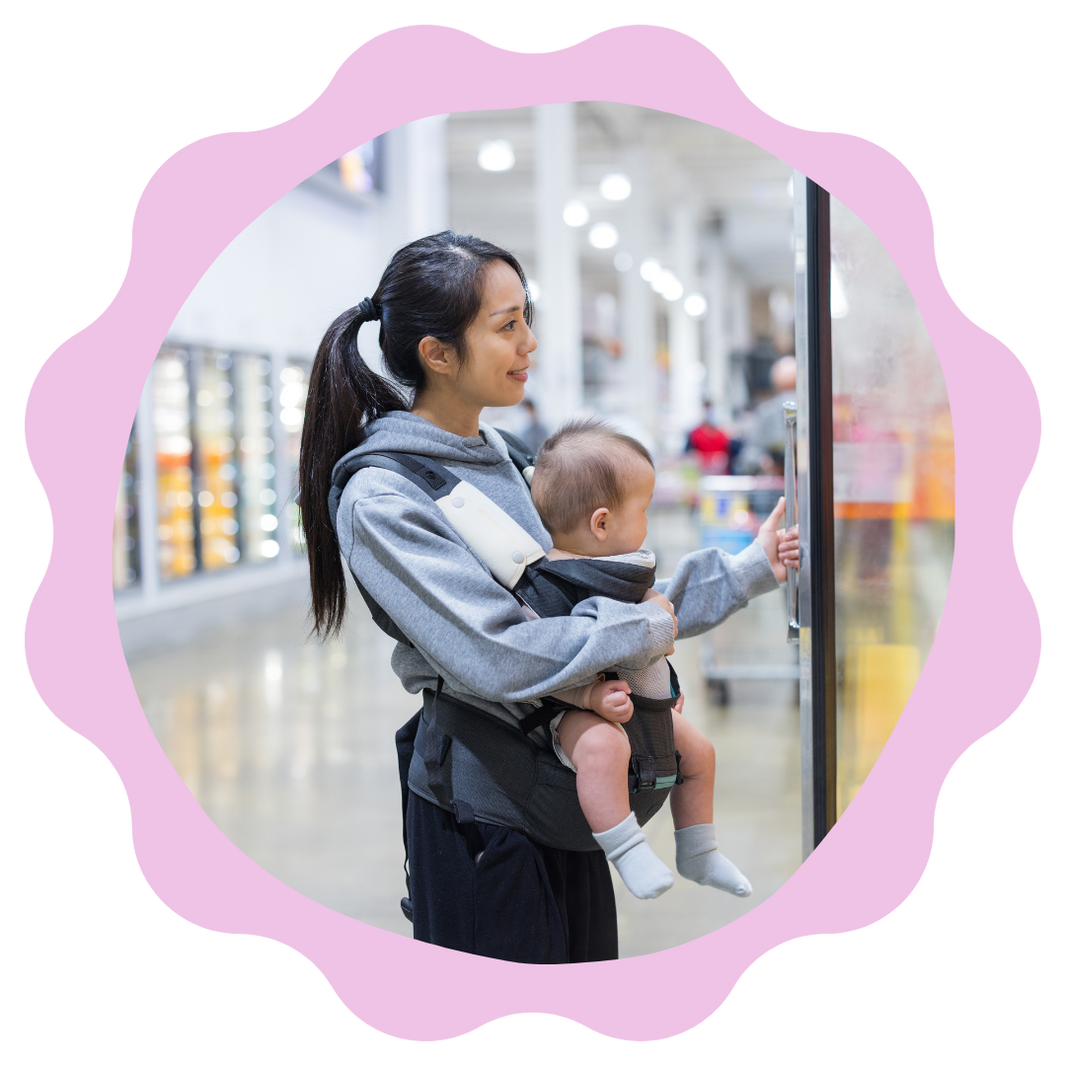 Woman carrying a baby in a sling at an airport.